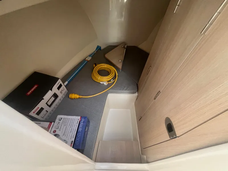 Slide: The Image of 2025 Bayliner Trophy T25 Pilothouse interior storage area with equipment and supplies. - 8