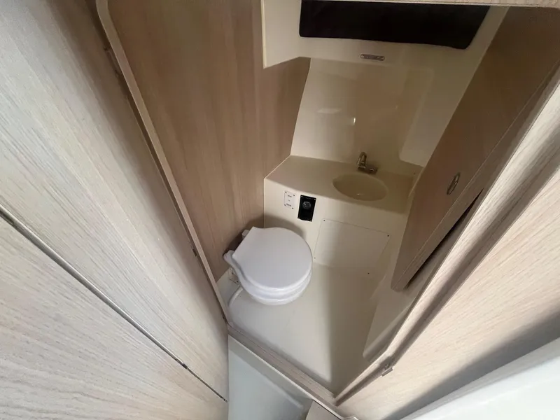 Slide: The Image of 2025 Bayliner Trophy T25 Pilothouse bathroom with compact toilet and sink. - 9