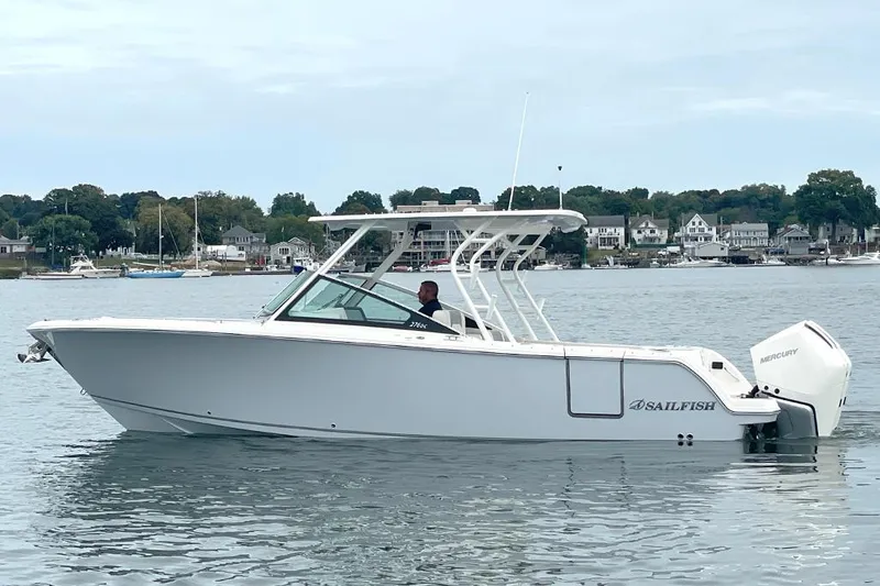 Slide: The Image of 2025 Sailfish 276 DC boat on calm water near a coastal town. - 3