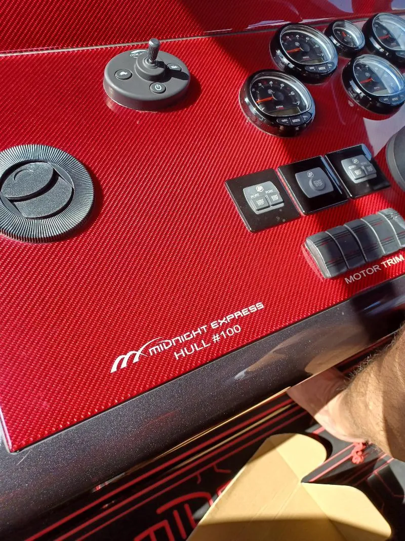Slide: The Image of Red dashboard of 2022 Midnight Express 43' Solstice boat with gauges and controls. - 11