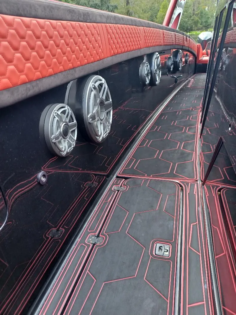 Slide: The Image of 2022 Midnight Express 43' Solstice boat interior with red accents and speaker system. - 13