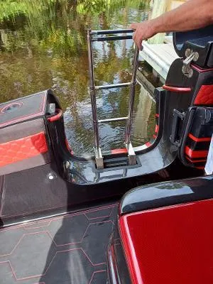 Slide: The Image of 2022 Midnight Express 43' Solstice boat with red and black interior, featuring a retractable ladder. - 14