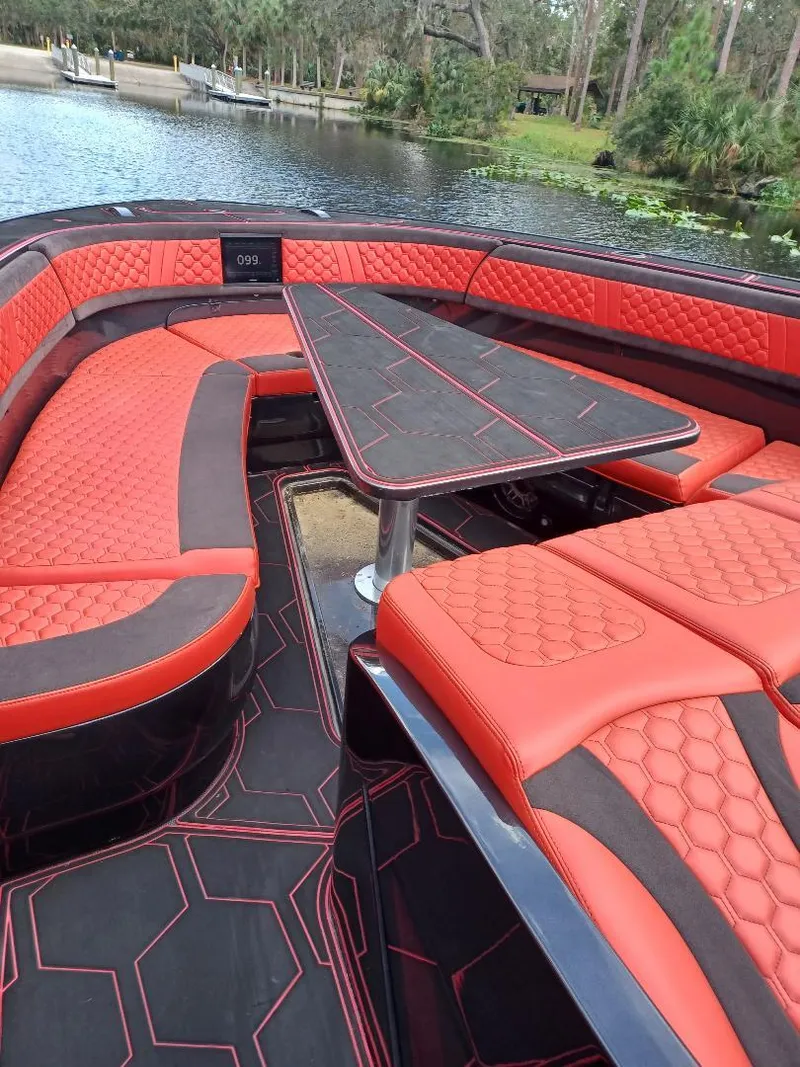 Slide: The Image of Luxurious 2022 Midnight Express 43' Solstice boat with red and black seating on a serene lake. - 16