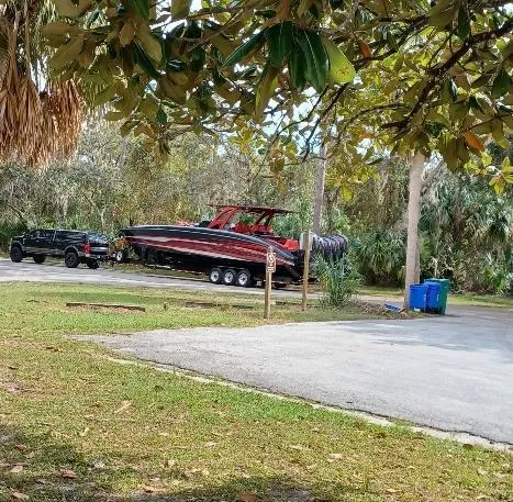Slide: The Image of Black truck towing 2022 Midnight Express 43' Solstice boat through a wooded area. - 37