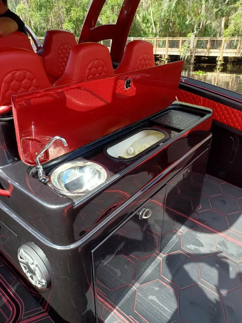 Slide: The Image of 2022 Midnight Express 43' Solstice boat interior with red seating and sleek kitchenette. - 7