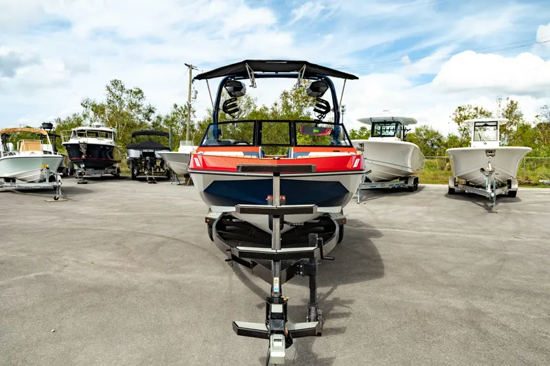 Slide: The Image of 2025 Nautique Super Air Nautique GS20 boat on trailer, surrounded by other boats. - 11