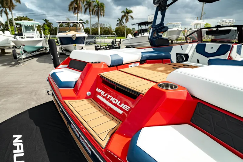 Slide: The Image of 2025 Nautique Super Air Nautique GS20 boat with red and white design, docked outdoors. - 13