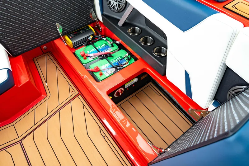 Slide: The Image of 2025 Nautique Super Air Nautique GS20 interior with battery compartment and cup holders. - 22