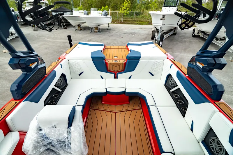 Slide: The Image of 2025 Nautique Super Air Nautique GS20 interior with white and blue seating, teak flooring. - 3
