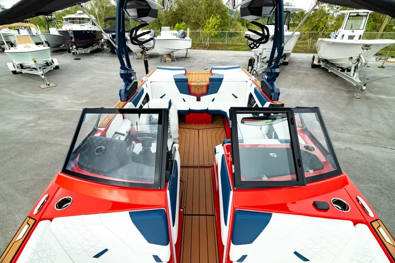 Slide: The Image of 2025 Nautique Super Air Nautique GS20 boat with vibrant red and white design, docked outdoors. - 49