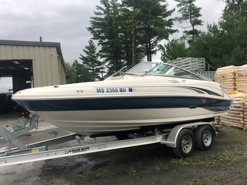 The Image of 2003 Sea Ray 200 Sundeck boat on trailer near storage facility. - 0