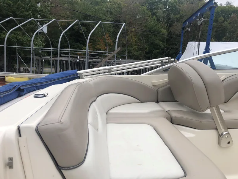 Slide: The Image of 2003 Sea Ray 200 Sundeck boat interior with beige seating and outdoor storage racks. - 5