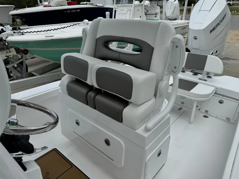 Slide: The Image of 2025 BlackJack 256 Coastal boat interior with cushioned seating and steering wheel. - 19