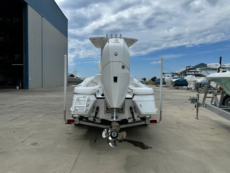 Slide: The Image of 2025 BlackJack 256 Coastal boat, rear view, parked in marina with cloudy sky. - 5