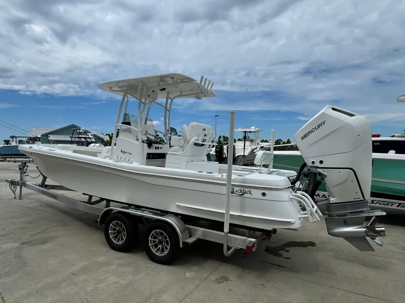 Slide: The Image of 2025 BlackJack 256 Coastal boat on trailer, featuring a Mercury outboard motor. - 6