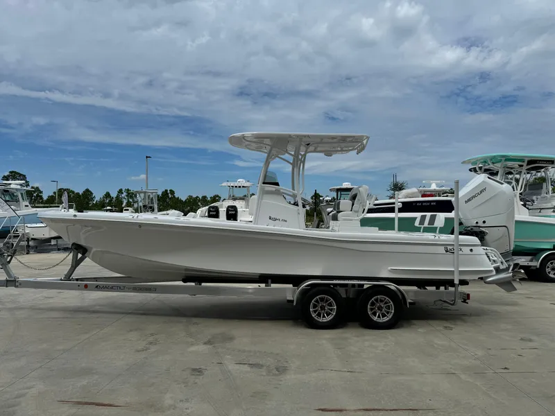 Slide: The Image of 2025 BlackJack 256 Coastal boat on trailer, parked outdoors under cloudy sky. - 7