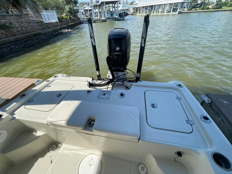 Slide: The Image of 2014 Triton 240 LTS Pro boat stern view with motor on a lake. - 18