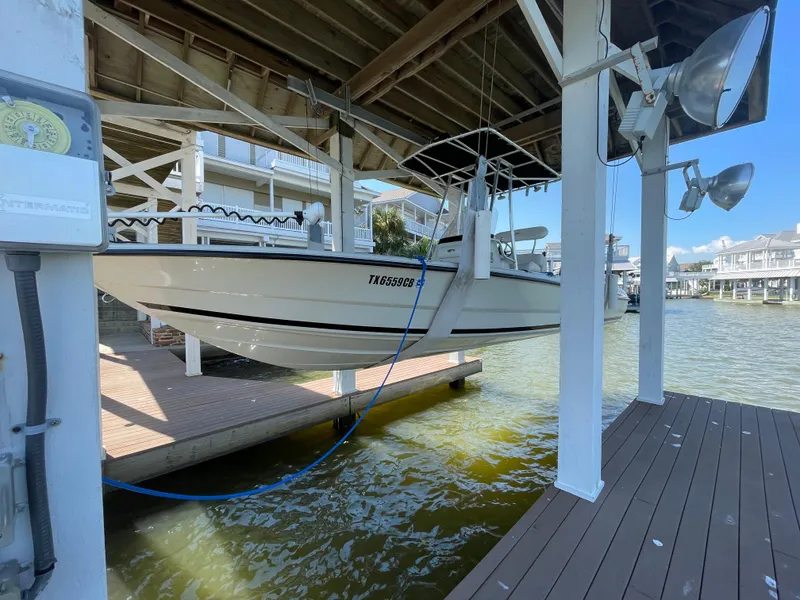 Slide: The Image of 2014 Triton 240 LTS Pro boat docked in a marina lift. - 4