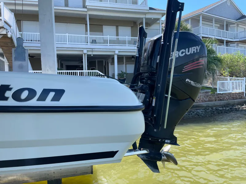 Slide: The Image of 2014 Triton 240 LTS Pro boat with Mercury outboard motor docked near waterfront homes. - 5