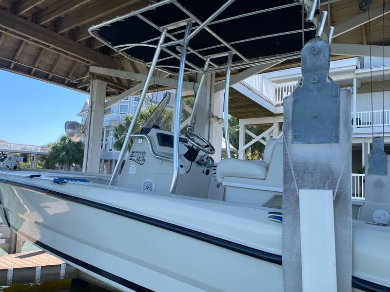 Slide: The Image of 2014 Triton 240 LTS Pro boat docked under a wooden shelter. - 6