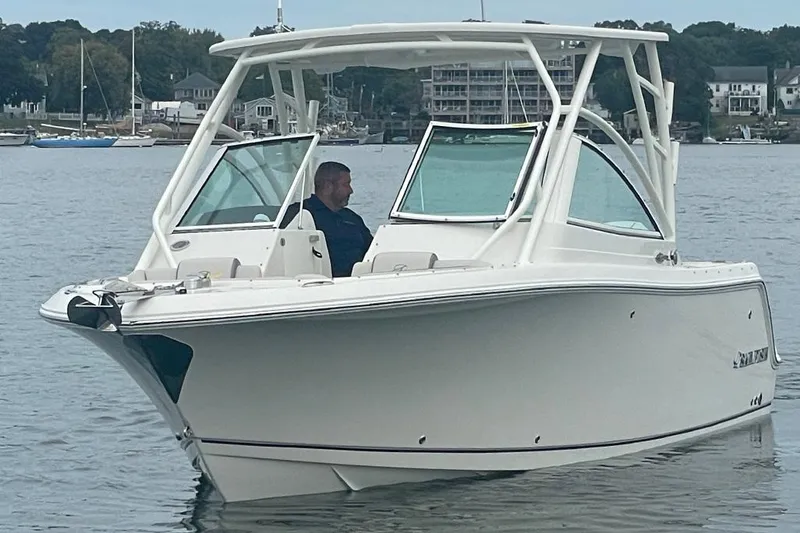 Slide: The Image of 2025 Sailfish 245 DC boat on calm water with a person at the helm. - 3