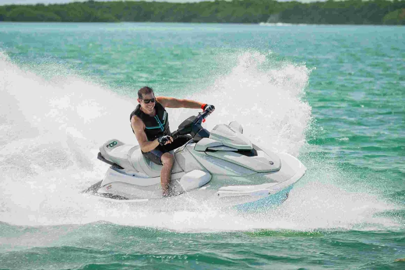 Slide: The Image of Man riding 2025 Waverunner VX CRUISER HO A jet ski on turquoise water. - 3