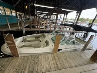 Slide: The Image of 2005 Sea Ray 240 Sundeck boat docked in a covered marina. - 3
