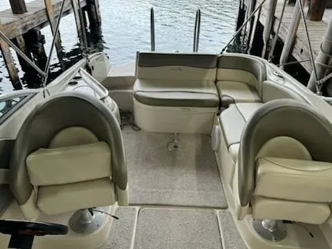 Slide: The Image of 2005 Sea Ray 240 Sundeck interior with beige seating and waterfront view. - 5