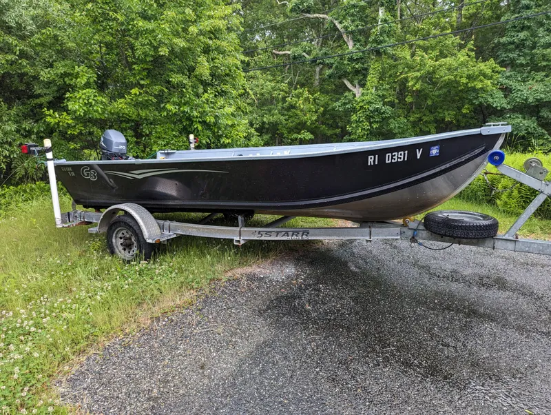 Slide: The Image of 2010 G3 Guide V16 boat on trailer, parked near lush greenery. - 4