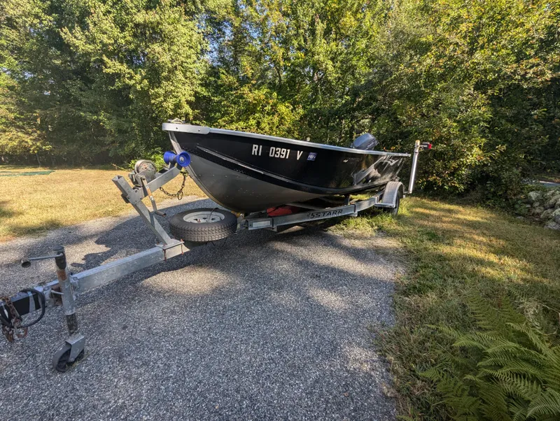 Slide: The Image of 2010 G3 Guide V16 boat on trailer, parked on gravel path near trees. - 6