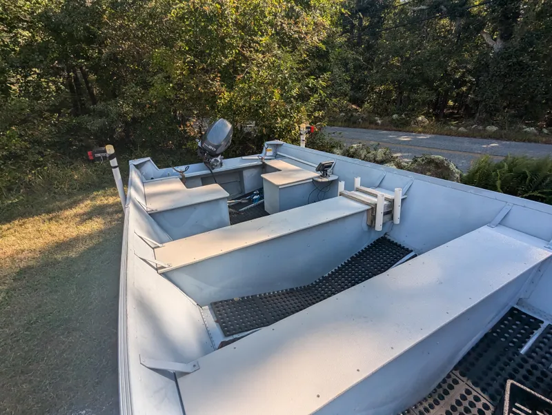 Slide: The Image of 2010 G3 Guide V16 boat with motor, parked outdoors near trees. - 8