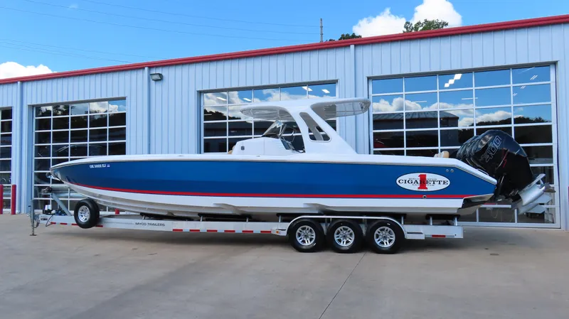 Slide: The Image of 2016 Cigarette 39 GTS boat on trailer outside a garage. - 2