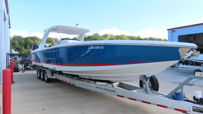 Slide: The Image of 2016 Cigarette 39 GTS boat on trailer, blue and white design, parked outdoors. - 4