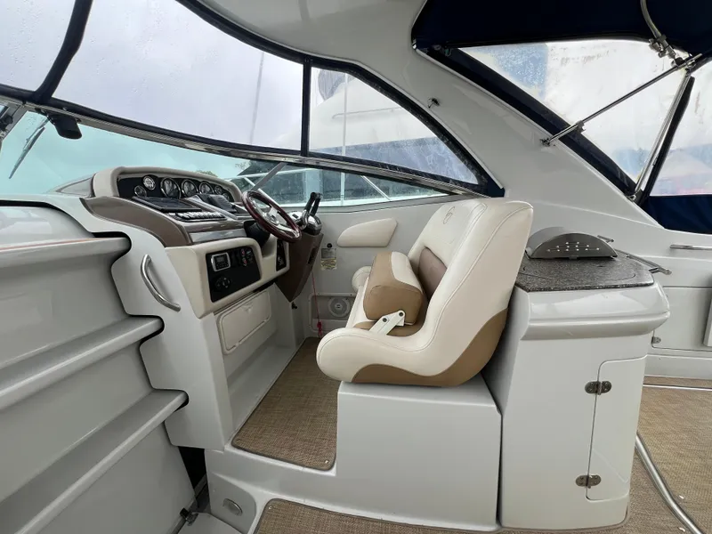 Slide: The Image of Interior of 2014 Crownline 294 CR boat, featuring helm and seating area. - 10