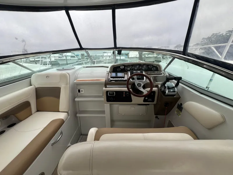 Slide: The Image of Interior of 2014 Crownline 294 CR boat, featuring helm and seating area. - 13