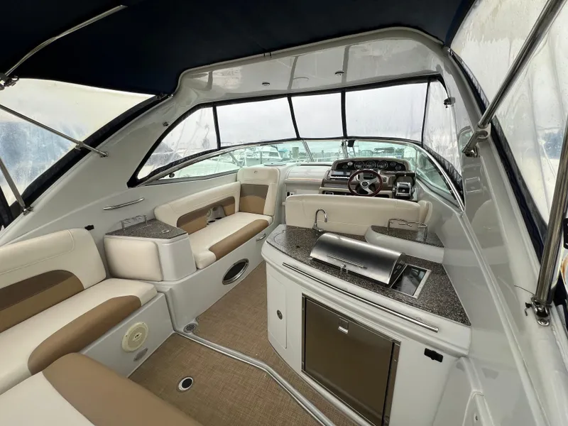 Slide: The Image of Interior of 2014 Crownline 294 CR boat with seating, kitchenette, and helm. - 2