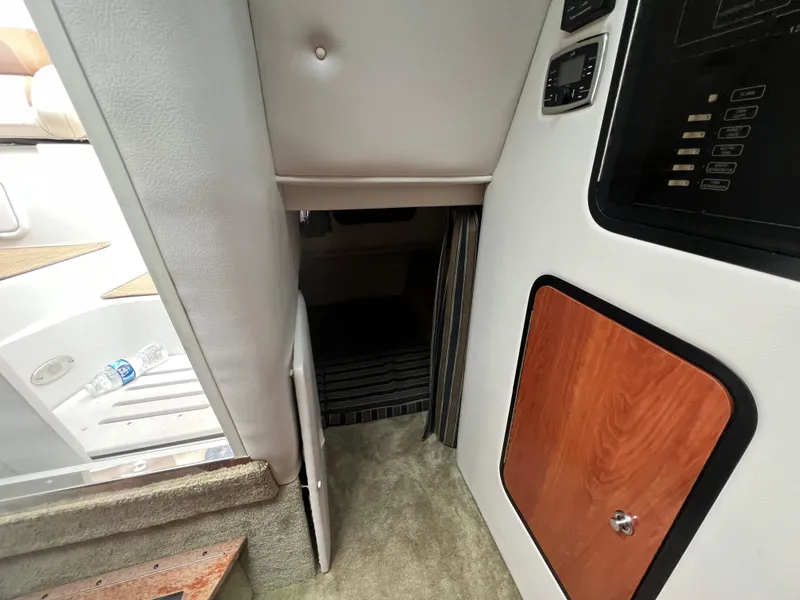 Slide: The Image of Interior cabin view of 2014 Crownline 294 CR boat, featuring steps and control panel. - 22