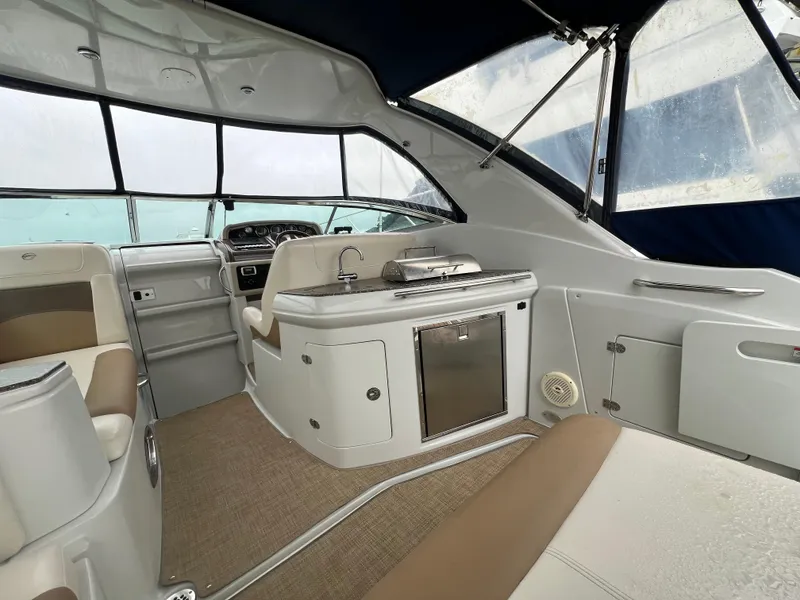 Slide: The Image of 2014 Crownline 294 CR boat interior with seating and kitchenette. - 9