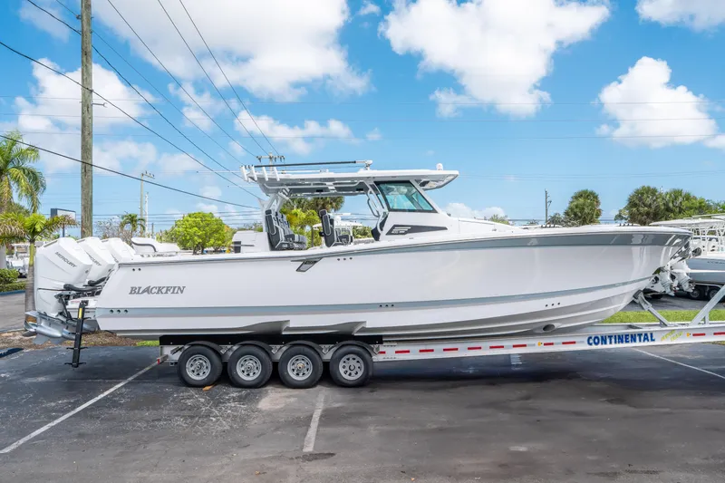 The Image of 2024 Blackfin 400CC boat on trailer, parked outdoors under a blue sky. - 0