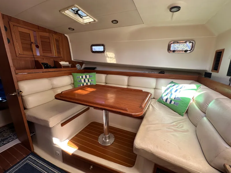 Slide: The Image of 2002 Mainship Pilot 34 interior with cozy seating and wooden table. - 10