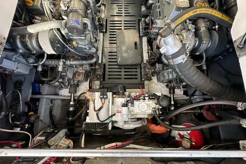 Slide: The Image of Engine compartment of a 2002 Mainship Pilot 34, showcasing mechanical components and wiring. - 13