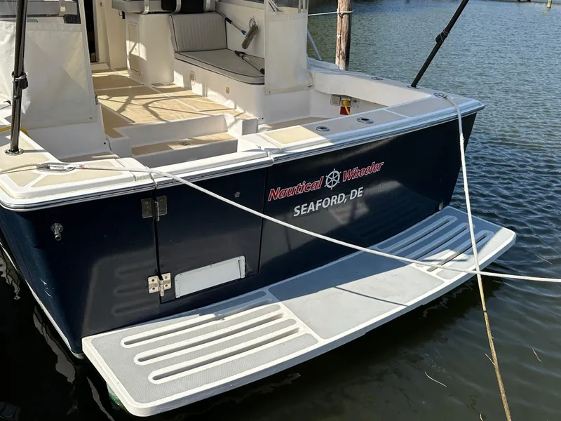 Slide: The Image of 2002 Mainship Pilot 34 boat docked, featuring spacious deck and sleek design. - 3