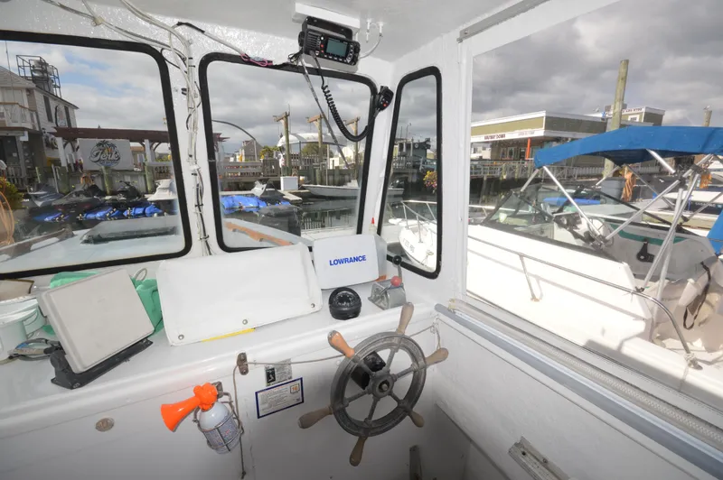 Slide: The Image of Interior view of 1983 BHM 25 EXPRESS boat cockpit with steering wheel and navigation equipment. - 11