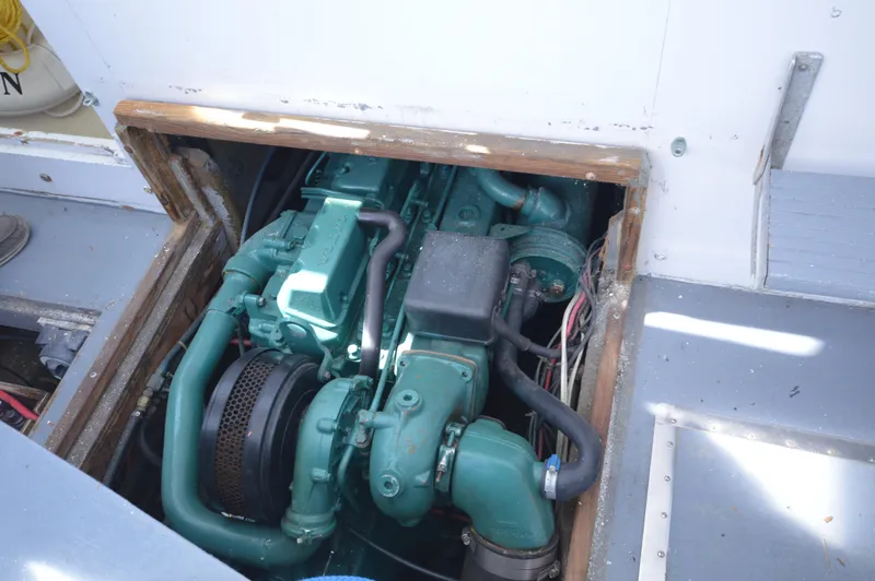 Slide: The Image of Engine compartment of 1983 BHM 25 EXPRESS boat, showcasing a green marine engine. - 13
