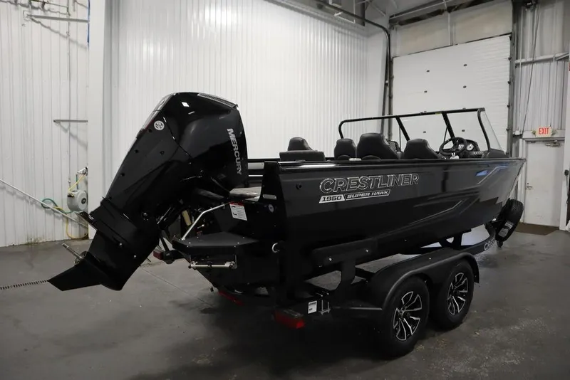 Slide: The Image of 2025 Crestliner 1950 Super Hawk boat in a garage, featuring a powerful Mercury outboard motor. - 5