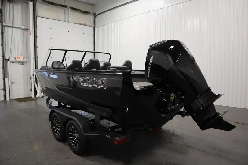 Slide: The Image of 2025 Crestliner 1950 Super Hawk boat with outboard motor in a garage setting. - 7