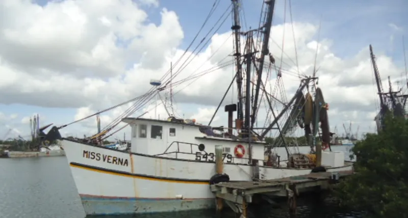 Slide: The Image of 1972 Commercial Shrimp Freezer Trawler docked at a pier under cloudy skies. - 0