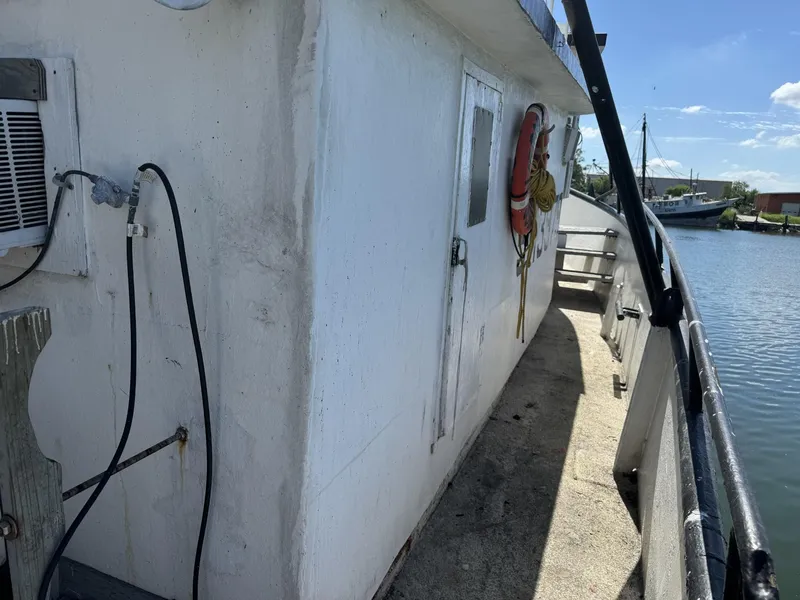 Slide: The Image of 1972 Commercial Shrimp Freezer Trawler deck with life preserver, docked by calm waters. - 3