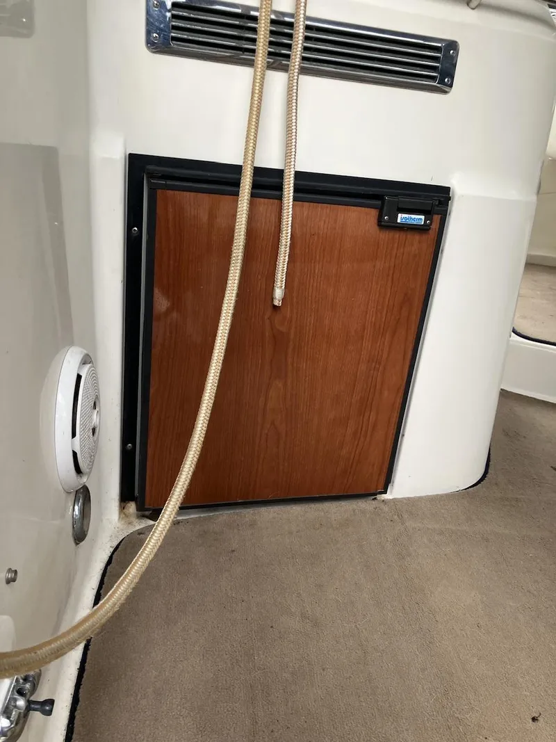 Slide: The Image of 2001 Doral 270 SC boat interior with wooden cabinet and beige carpet. - 4