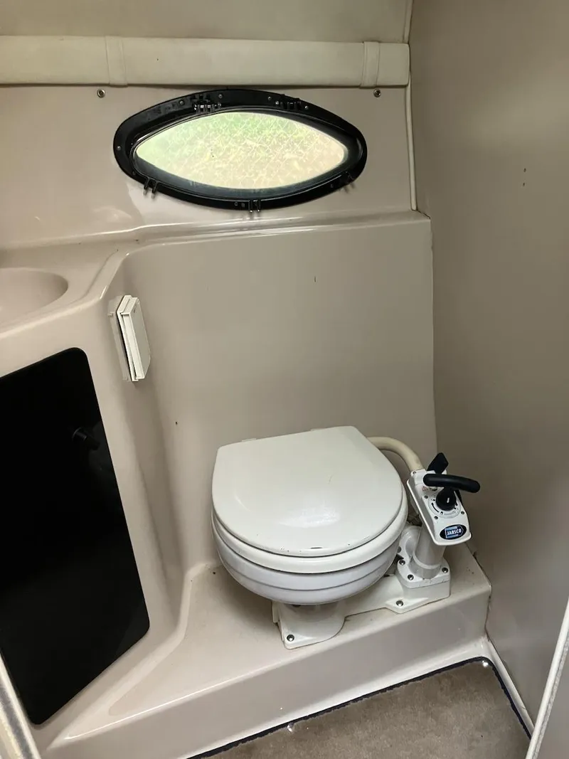 Slide: The Image of 2001 Doral 270 SC boat bathroom with compact toilet and porthole window. - 5